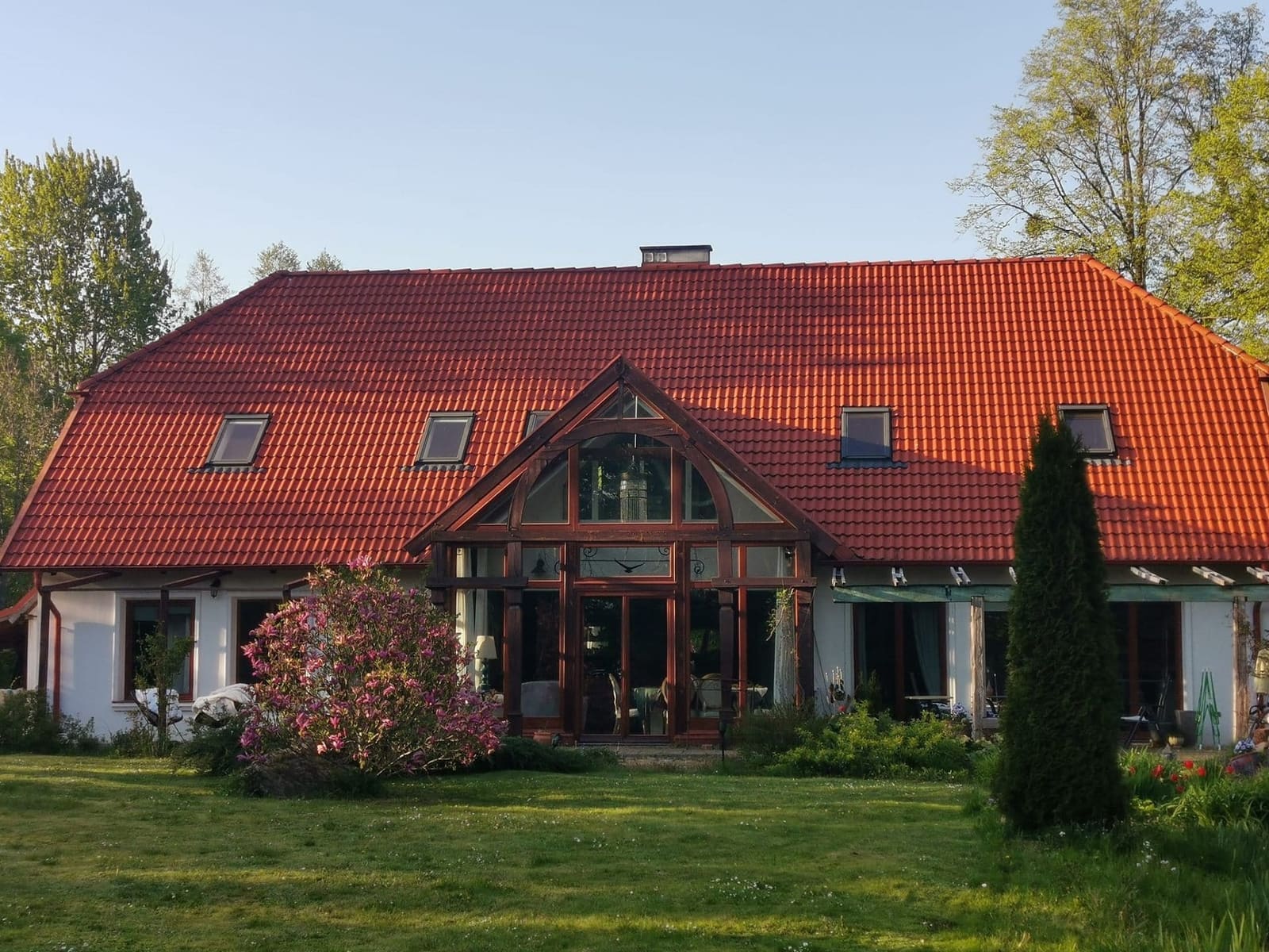 Piękny dom na mazurskiej wsi z czerwonym dachem i ogrodem
